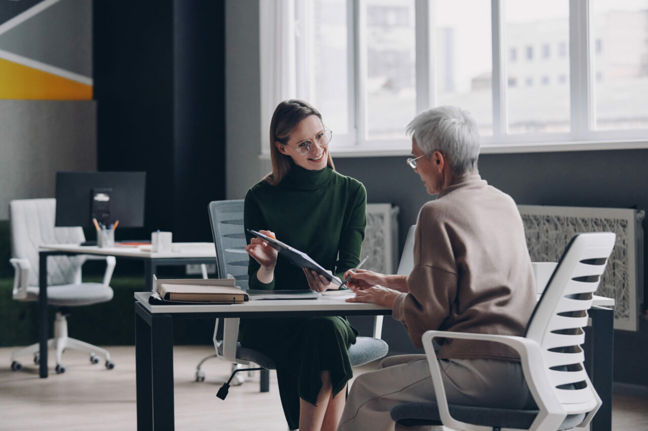 Senior woman having a meeting with financial advisor while sitting in the office together
