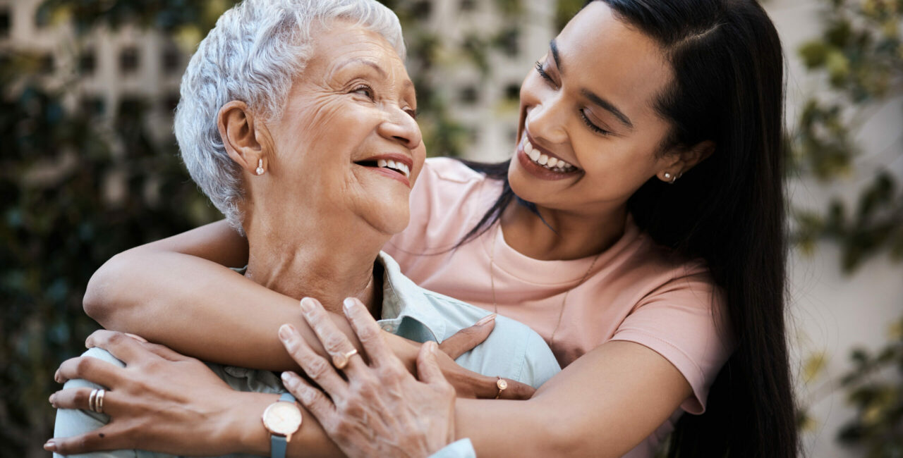 Happy, hug and loving of a mother and woman in a garden on mothers day with care and gratitude together. Smile, family and an adult daughter hugging a senior mom in a backyard or park for happiness
